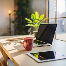 a laptop and a cup of coffee on a desk