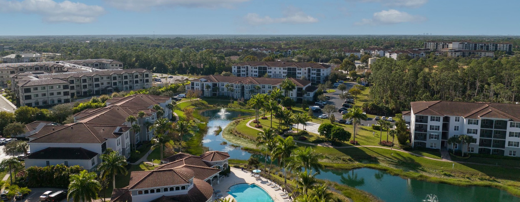 an aerial view of a property with a pool and a pond